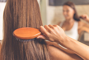 woman brushing hair - Copyright – Stock Photo / Register Mark