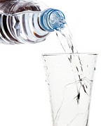 Bottled water being poured into a glass. - Copyright – Stock Photo / Register Mark