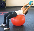 Chelsea Cooper demonstrating Long-Lever Ball Crunch with Medicine Ball. - Copyright – Stock Photo / Register Mark