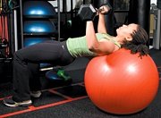 Chelsea Cooper performing stability ball barbell press. - Copyright – Stock Photo / Register Mark