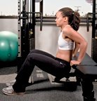 Chelsea Cooper demonstrates a tricep bench dip. - Copyright – Stock Photo / Register Mark