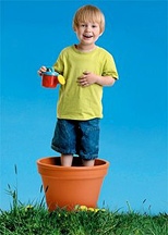 A young boy standing in a flower pot and holding a toy watering can. - Copyright – Stock Photo / Register Mark