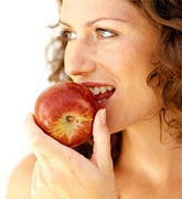Woman taking a bite of an apple. - Copyright – Stock Photo / Register Mark