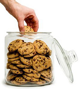 A man's hand removing a chocolate chip cookie for the cookie jar. - Copyright – Stock Photo / Register Mark