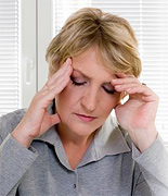 A middle aged woman holding her head suffering from a headache.
