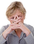 A middle aged woman holding her head suffering from a headache.