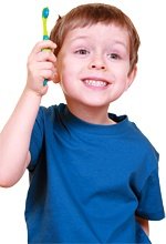 A smiling child brandishing a toothbrush. - Copyright – Stock Photo / Register Mark