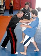Pat Miletich demonstrates the importance of balance to two young fighters. - Copyright – Stock Photo / Register Mark