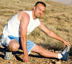 A man stretches his legs before running. - Copyright – Stock Photo / Register Mark