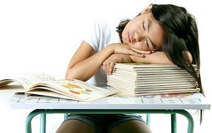 Little girl asleep on a stack of books on her school desk. - Copyright – Stock Photo / Register Mark