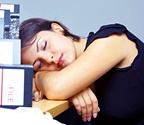 A young woman sleeping at her desk. - Copyright – Stock Photo / Register Mark