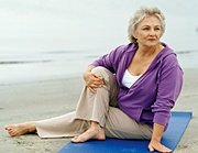 Elderly woman doing yoga on beach. - Copyright – Stock Photo / Register Mark