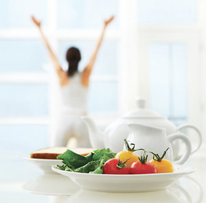 A woman doing yoga and a healthy lunch on a dining table. - Copyright – Stock Photo / Register Mark
