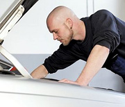Man under the hood of his car tunning it up. - Copyright – Stock Photo / Register Mark