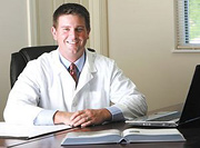 Doctor of Chiropractic at his desk. - Copyright – Stock Photo / Register Mark