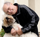 An older man hugs his dog to him. - Copyright – Stock Photo / Register Mark