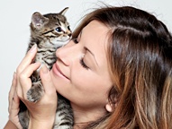 A woman holds her kitten to her face. - Copyright – Stock Photo / Register Mark