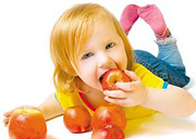 Little girl laying down and eating an apple. - Copyright – Stock Photo / Register Mark