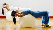 Two women doing stomach exercises on exercise balls. - Copyright – Stock Photo / Register Mark