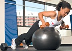 Chelsea Cooper demonstrates a ball dumbbell row. - Copyright – Stock Photo / Register Mark