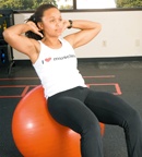 Chelsea Cooper demonstrating a Ball Crunch. - Copyright – Stock Photo / Register Mark