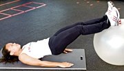 Chelsea Cooper demonstrates a stability ball leg curl. - Copyright – Stock Photo / Register Mark
