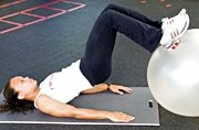 Chelsea Cooper demonstrates a stability ball leg curl. - Copyright – Stock Photo / Register Mark