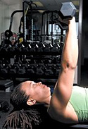 Chelsea Cooper performing flat bench dumbbell chest press. - Copyright – Stock Photo / Register Mark