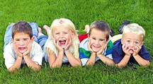 Four children laying in the grass. - Copyright – Stock Photo / Register Mark
