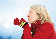 Woman blowing snow off of her gloves. - Copyright – Stock Photo / Register Mark