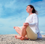 A woman meditating at the beach. - Copyright – Stock Photo / Register Mark