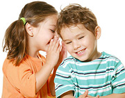 A little girl whispering in a little boy's ear. - Copyright – Stock Photo / Register Mark