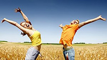 An energetic man and woman flinging their arms in the air. - Copyright – Stock Photo / Register Mark