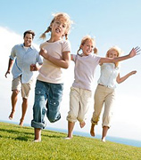 A family of four running toward the camera. - Copyright – Stock Photo / Register Mark