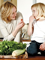 A mother and young daughter enjoy a salad together. - Copyright – Stock Photo / Register Mark
