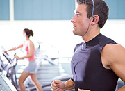 A man running on a treadmill at a gym. - Copyright – Stock Photo / Register Mark