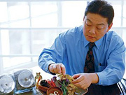 Chinese herbalist sorts through herbal medicines. - Copyright – Stock Photo / Register Mark