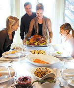 Family sitting down to carve the turkey on Thanksgiving. - Copyright – Stock Photo / Register Mark