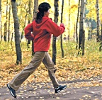 Woman power walking through autumn backroad. - Copyright – Stock Photo / Register Mark