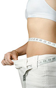An inshape woman measuring her waist with a tape measure. - Copyright – Stock Photo / Register Mark