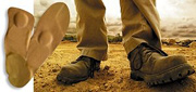 Pair of work boots standing at work site. - Copyright – Stock Photo / Register Mark