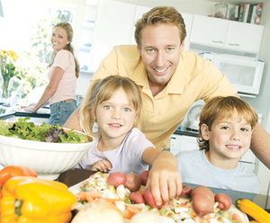 A young family of four preparing a healthy lunch. - Copyright – Stock Photo / Register Mark