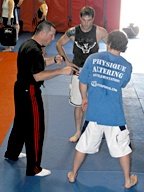 Pat Miletich demonstrates the importance of balance to two young fighters. - Copyright – Stock Photo / Register Mark