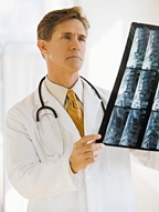 A doctor examining Xrays of a patient's spine. - Copyright – Stock Photo / Register Mark