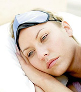 A woman lying awake in bed. - Copyright – Stock Photo / Register Mark