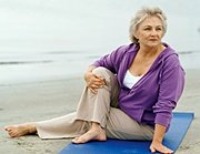 Elderly woman doing yoga on beach. - Copyright – Stock Photo / Register Mark